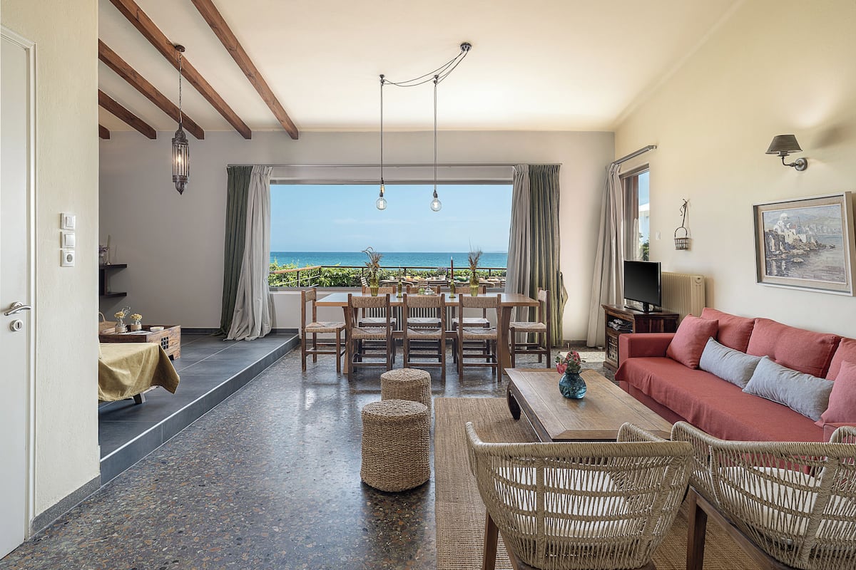Una sala de estar con vista al mar, un comedor y un sofá.