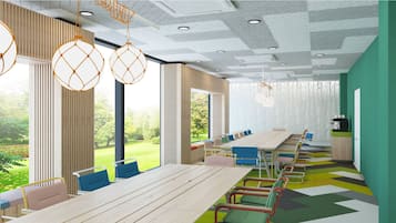 Una sala de reuniones moderna con una mesa larga, sillas coloridas y grandes ventanales con vista a un jardín.