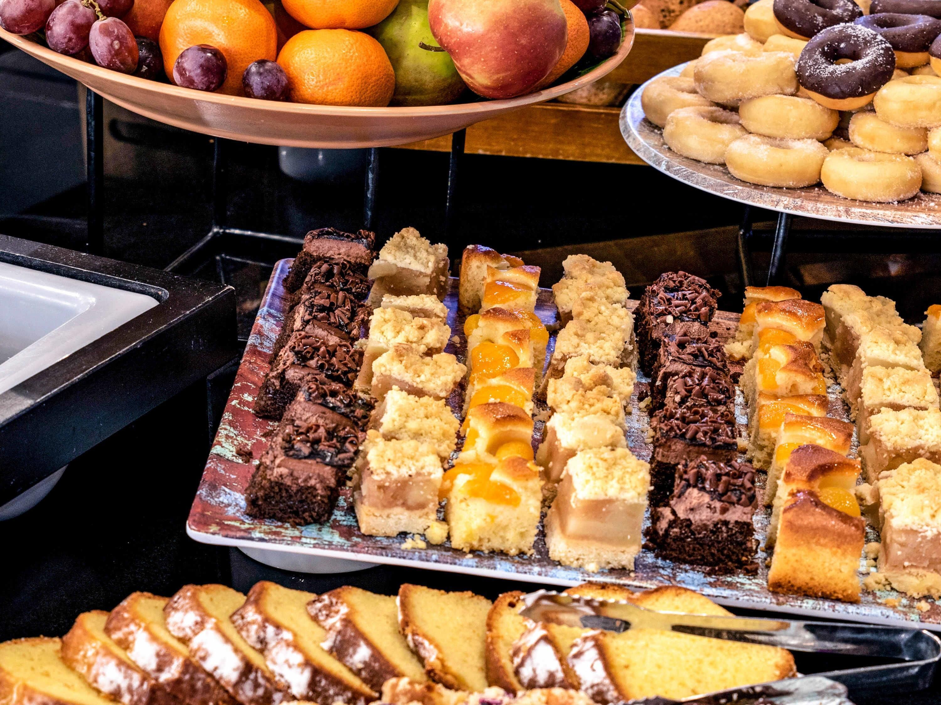 A buffet with various desserts and fruits.