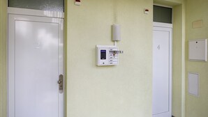 Un pasillo con dos puertas, con los números 2 y 4, y un panel de seguridad en la pared.