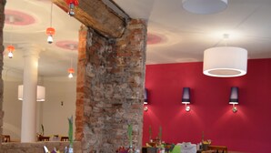 A dining area with brick walls, wooden tables, and chairs. - Hotel Turmdieb (Volkach)