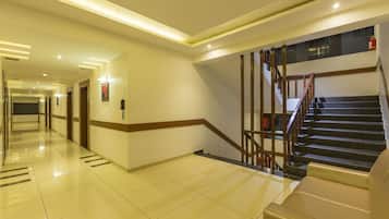 Eine moderne Hotelhalle mit einer langen Korridor, einer Treppe und einem Empfangsbereich.