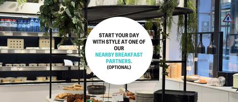 A breakfast buffet area with various food items and a circular sign promoting nearby breakfast partners.