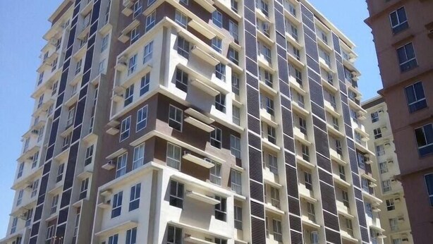 Un edificio residencial de varios pisos con un diseño arquitectónico moderno, que cuenta con balcones y un acceso con puerta de seguridad.