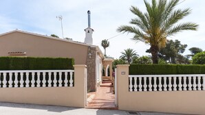 A gated entrance with a pathway leading to a building, surrounded by well-maintained hedges and palm trees. - FREDERIC - Villa with private pool in Xàbia. (Xàbia)