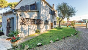 Ein rustikales Haus mit Steinfassade, Holzhörnern und einem kleinen Garten mit einem Weg zum Eingang.