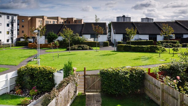 A residential area with modern apartment buildings, a well-maintained lawn, and a wooden gate. - Elforma - Tudsbery House (Edinburgh)