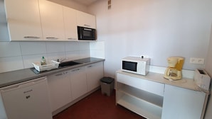 A compact kitchen with white cabinets, a microwave, a coffee maker, and a toaster. - 2-room apartment, sleeps 5 with balcony - Saint-Jean-de-Monts (Saint-Jean-de-Monts)