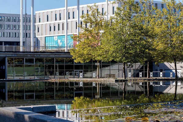 Un edificio moderno con fachada de vidrio que refleja los alrededores.