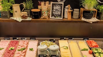 A food display with various meats, cheeses, and vegetables.