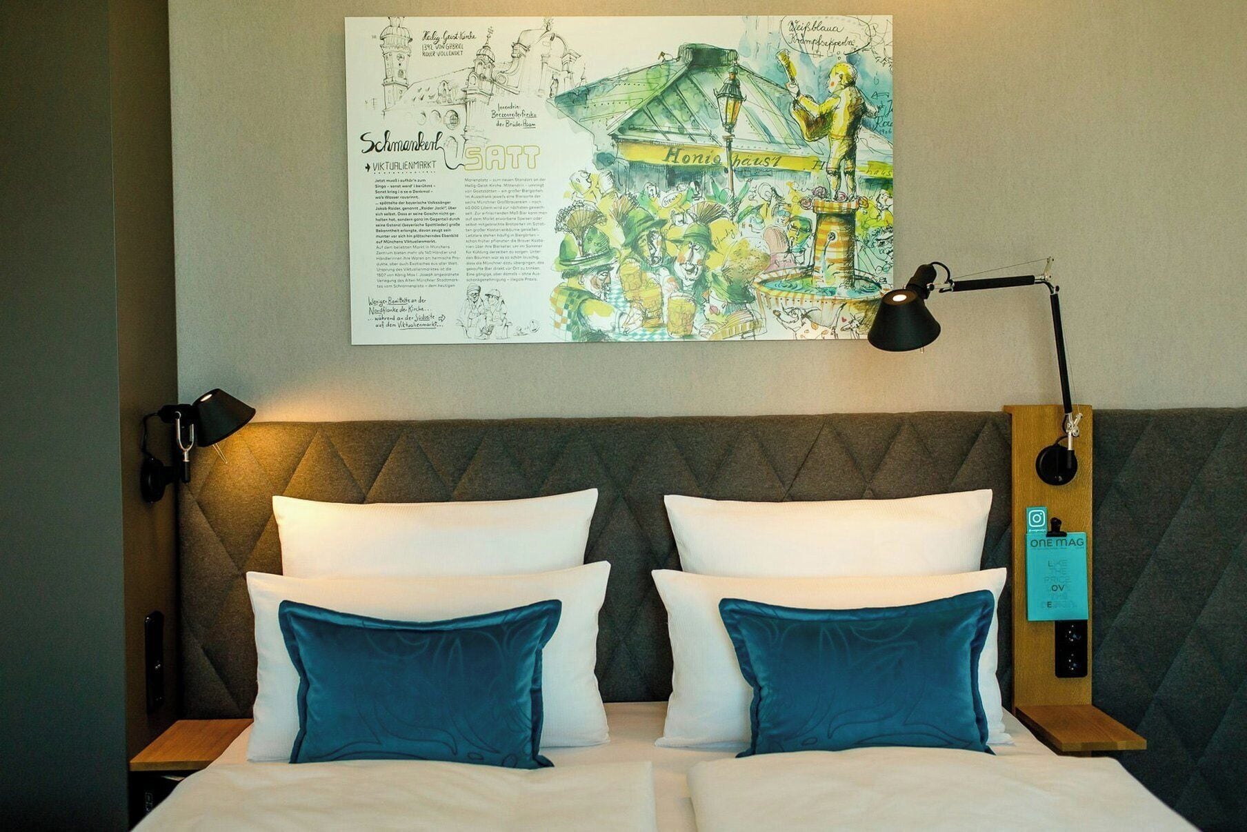 A hotel room with a bed, two pillows, a nightstand, a lamp, and a wall-mounted artwork.