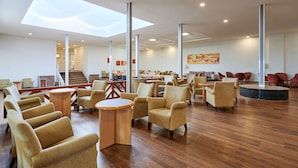 A spacious lobby with high ceilings, a skylight, and a central staircase. -    AluaSun Cala Antena – All Inclusive (Manacor)