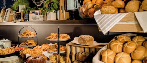 Un bufé con diversos productos de panadería y pastelería.