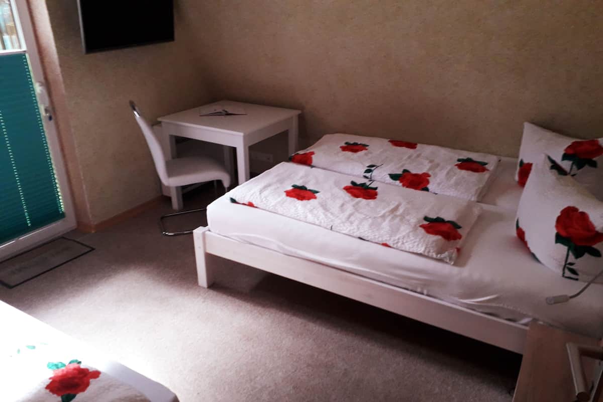 Une chambre à coucher avec un lit, un petit bureau et une chaise.