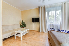 Relax in this serene space with a comfortable bed, a flat-screen TV, and a stylish sofa.