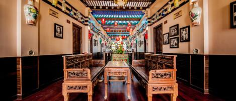 Un interior tradicional con muebles de madera, una mesa central y faroles decorativos.