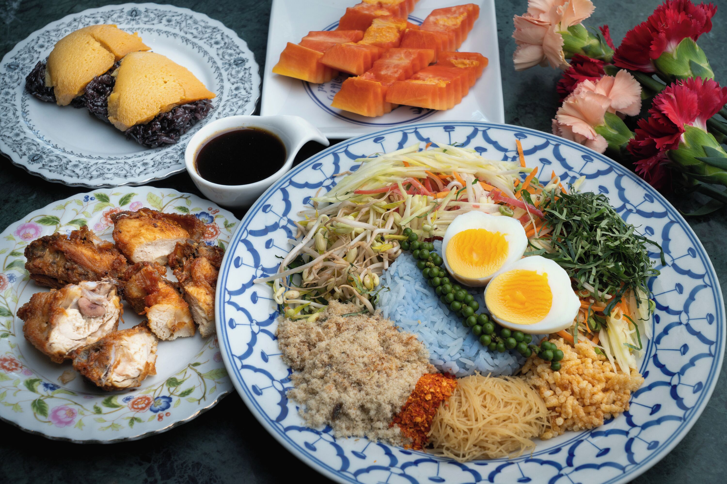 A table with various dishes including rice, vegetables, and meat.