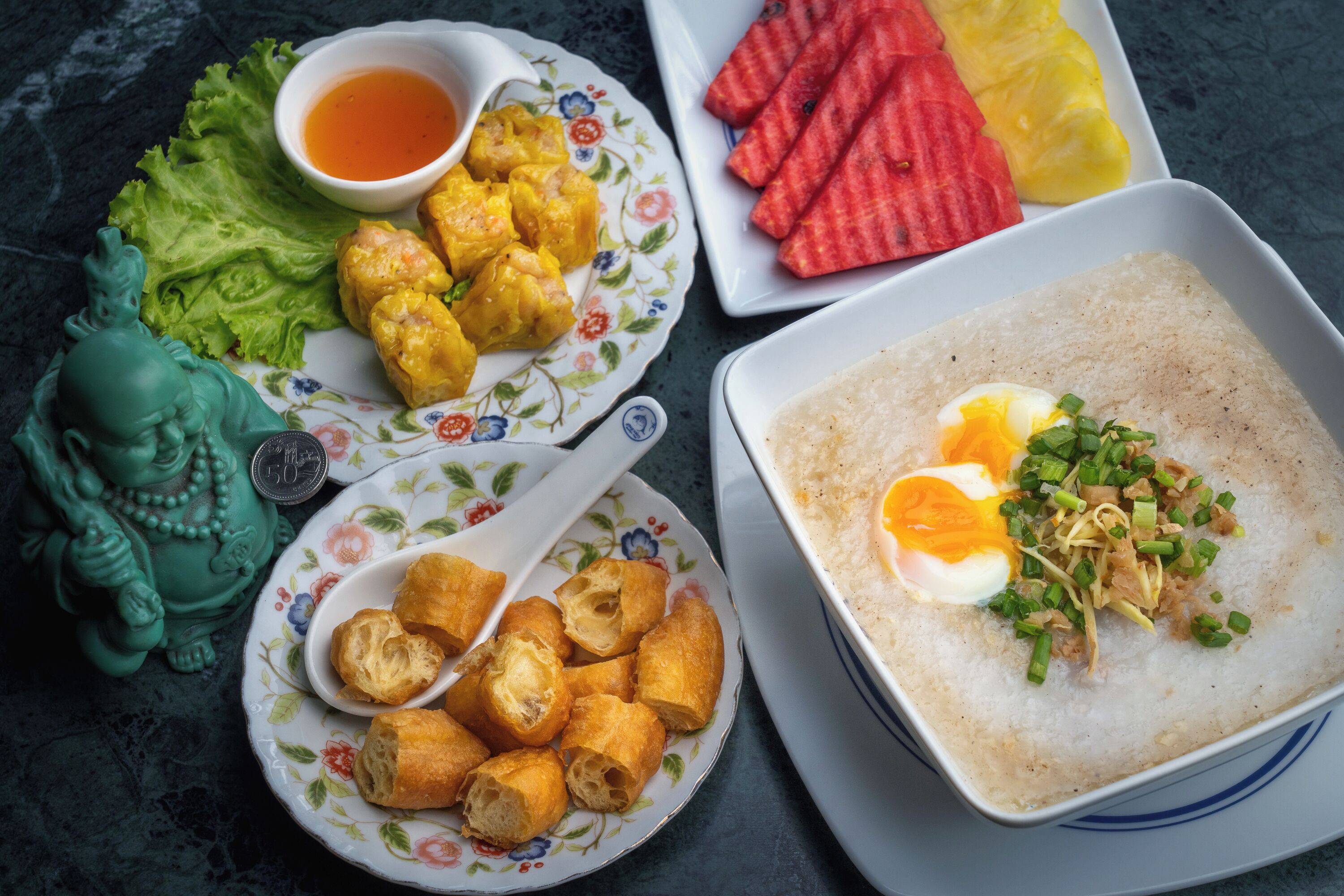 A variety of dishes including fried items, a bowl of soup, and fresh vegetables.