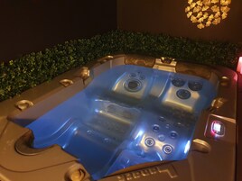 Un jacuzzi con múltiples chorros, un panel de control y una pantalla digital.