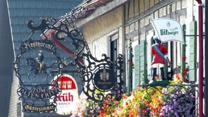 A building with a sign that reads "Zum Alten Fritz" and "Bierburger". There is a statue of a person on the roof, and a flower basket hanging from the front. - Landgasthaus Zum Alten Fritz (Asbach)