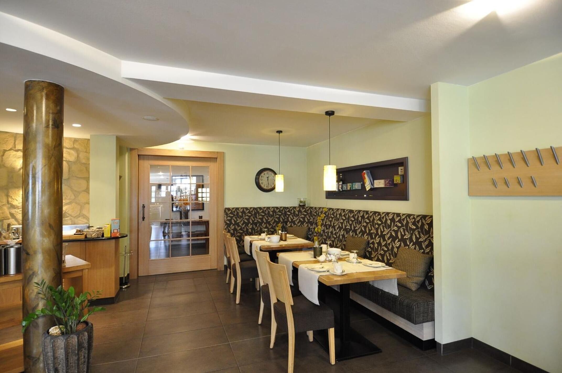 Un restaurant doté d’un long comptoir, de chaises en bois et d’un espace salon avec un canapé.
