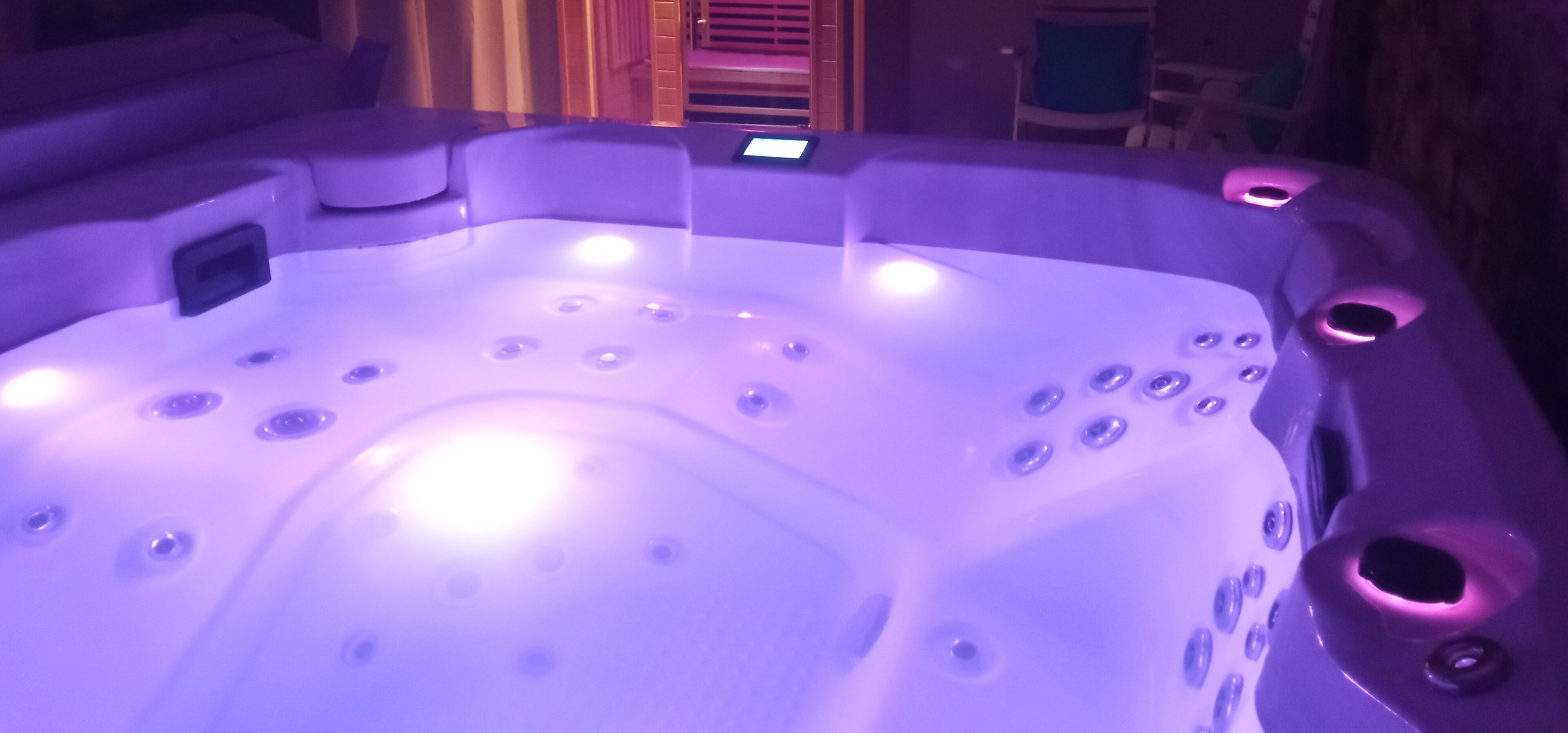 Un jacuzzi con múltiples chorros, un panel de control y una zona de estar.
