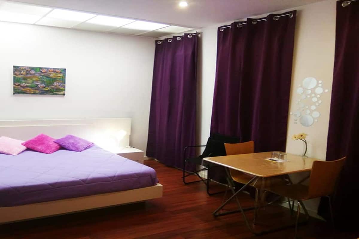 Ein Schlafzimmer mit einem Bett, einem Schreibtisch und einem Stuhl.