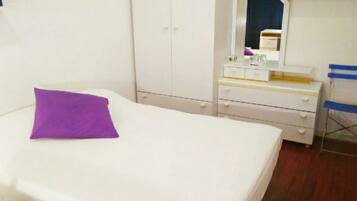 Un dormitorio con cama, cómoda, espejo y silla.