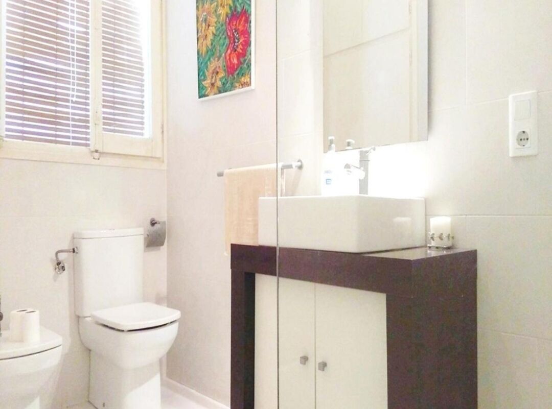 A bathroom with a toilet, a sink, and a cabinet.