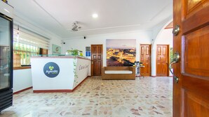 Un área de recepción con suelo de baldosas, un mostrador y un espacio de descanso.