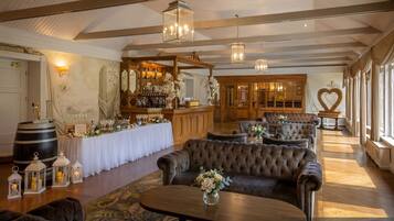 A spacious lounge area with a bar, seating, and a view of the outdoors.