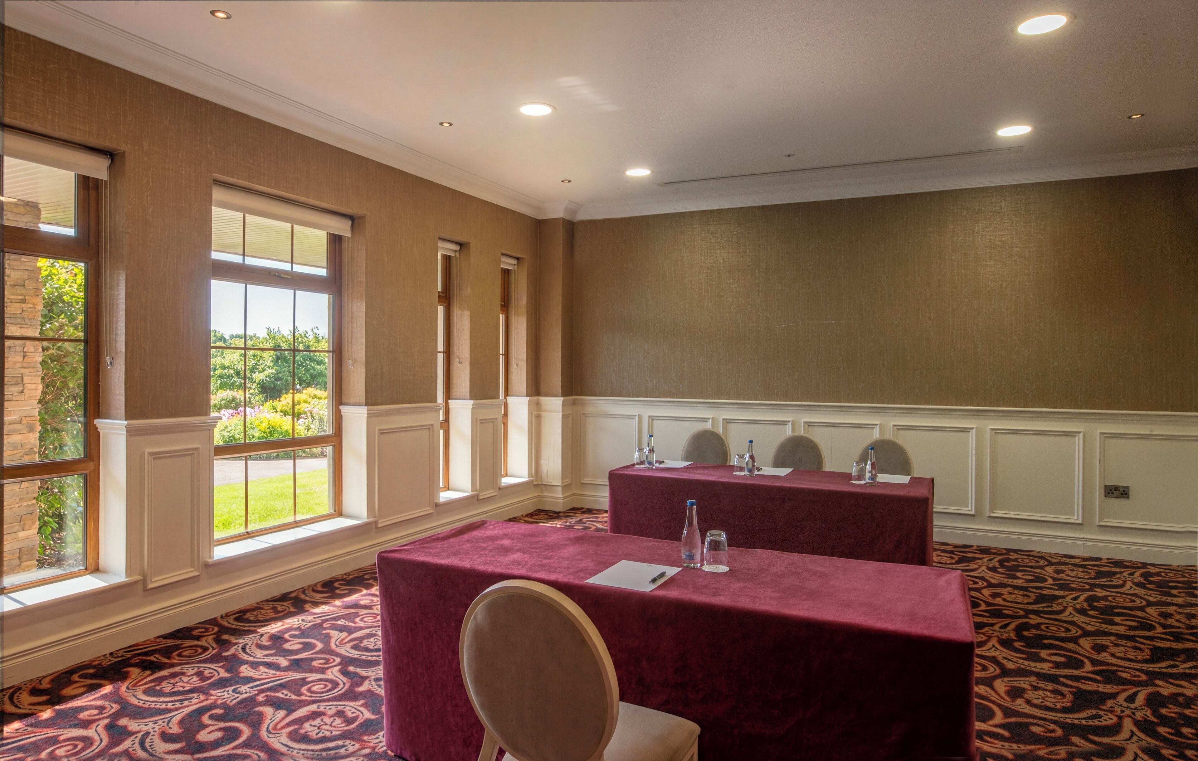 A conference room with a large table, chairs, and a carpeted floor.