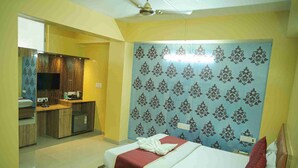 Une chambre d’hôtel avec un lit, une petite kitchenette et une salle de bain.