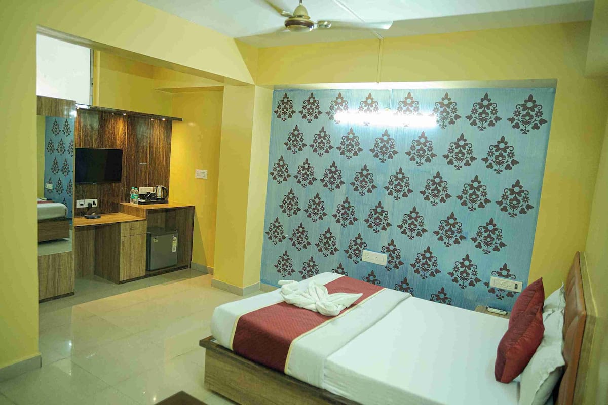 Una habitación de hotel con cama, una kitchenette pequeña y un baño.