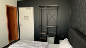 A hotel room with a bed, a wardrobe, and a door. - MOTELO Bielefeld (Bielefeld)