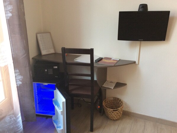 A small office space with a desk, chair, and a flat-screen TV mounted on the wall. - B&B La Maison d'Olivier (Beaucaire)