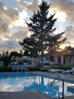Una piscina al aire libre de temporada, sombrillas