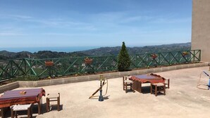 A rooftop terrace with a view of the landscape, a table with chairs, and a hookah. - Hasdikoz Abdik Hotel (Of)