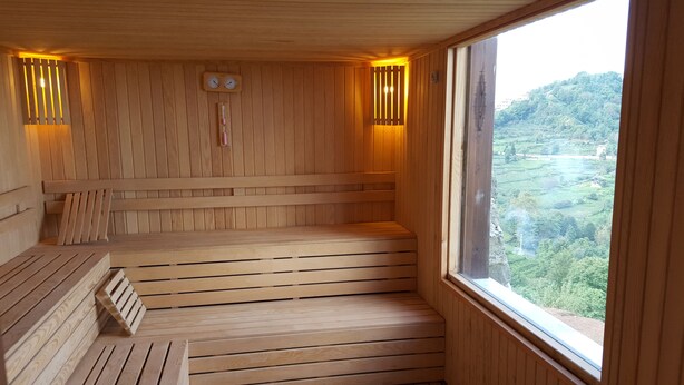 A wooden sauna with benches and a view of a green landscape. - Hasdikoz Abdik Hotel (Of)