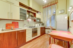 Compact kitchen with sink, stove, microwave, and refrigerator, perfect for preparing meals.