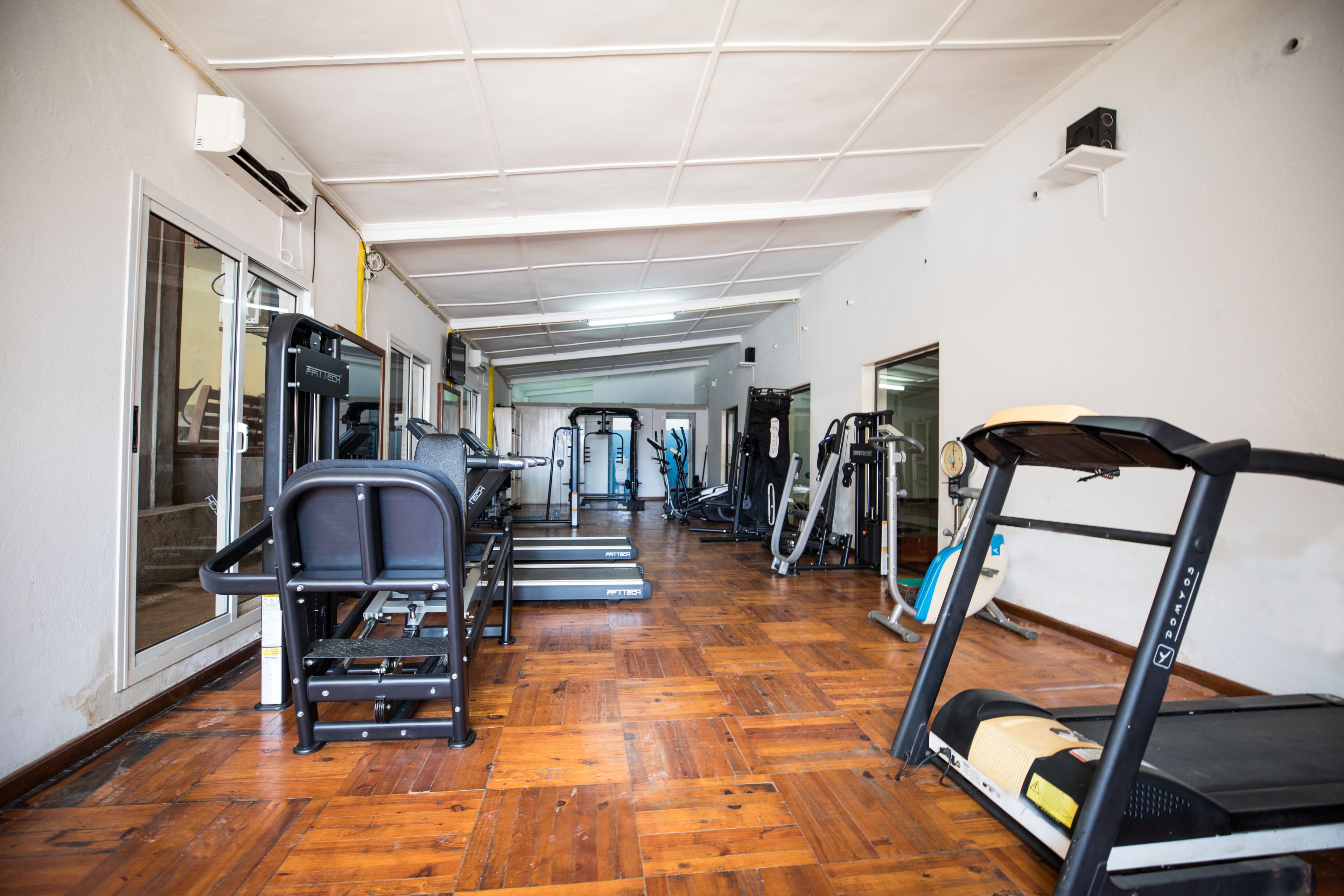 Un gimnasio con cintas de correr, bicicletas estáticas y máquinas de pesas.