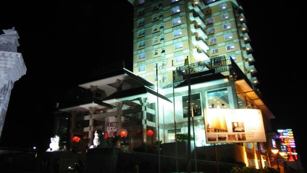 A multi-story hotel with illuminated balconies and a prominent signboard. - Sogecoa Apart Hotel (Maputo)