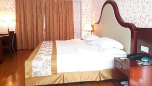 A hotel room with a bed, a desk, a chair, a lamp, and an air conditioning unit. - Sogecoa Apart Hotel (Maputo)