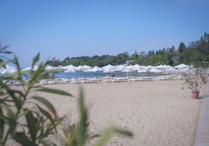 Liegestühle, Sonnenschirme, Strandtücher, Volleyball