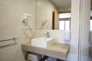 A modern bathroom with a white sink, a towel rack, a mirror, and a hand dryer. - La Posada de Ojebar (Rasines)