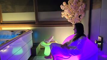 Relax in a spacious room with a large bathtub and comfortable seating area.