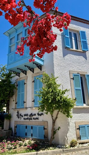 A two-story building with blue shutters, a balcony, and a sign that reads 'Boutique Hotel.' - Kozanogluhan Boutique Hotel (Cesme)