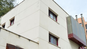 Ein modernes Gebäude mit flacher Fassade, großen Fenstern und einem gut sichtbaren Eingang.