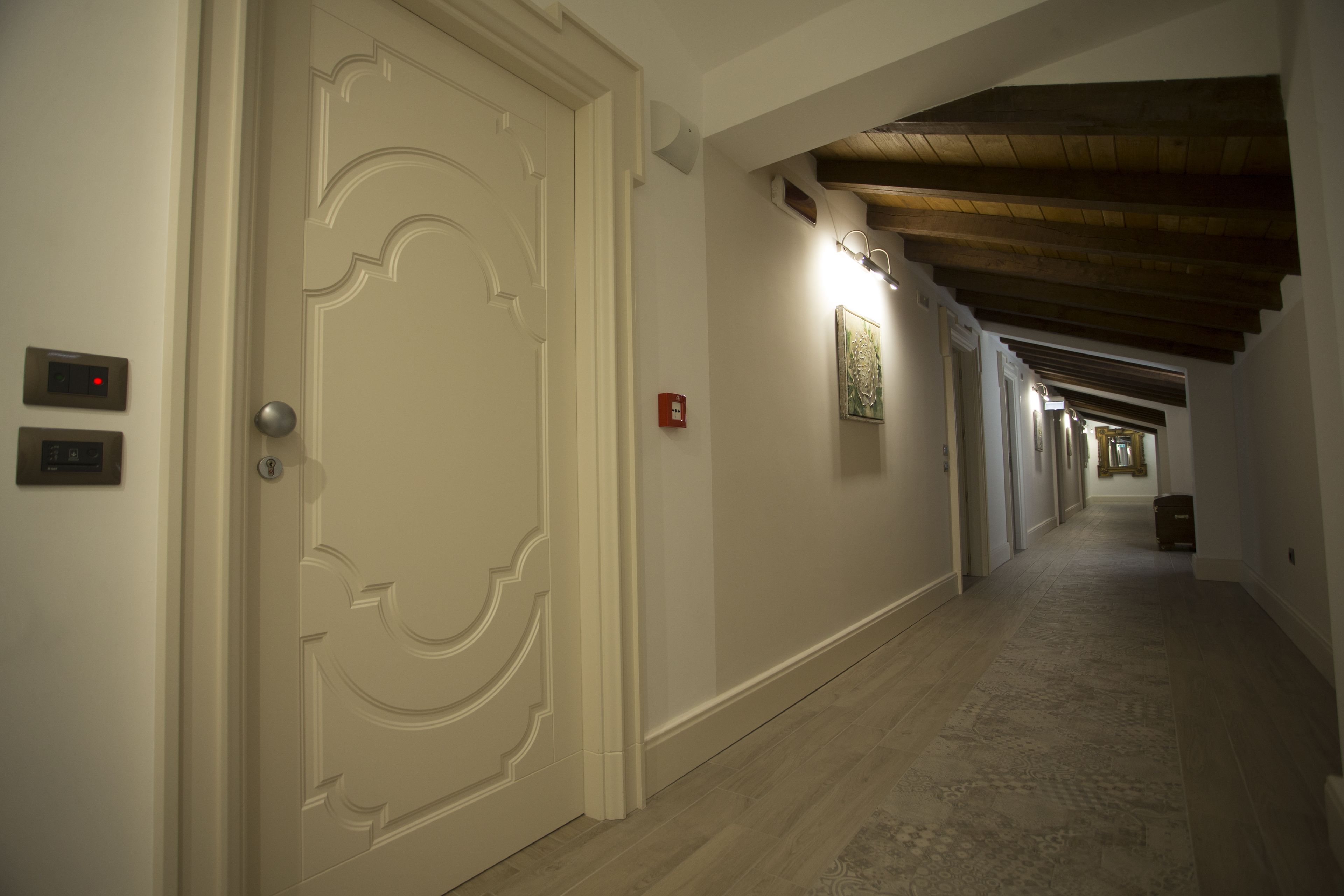 Un corridoio con soffitto in legno e pavimento rivestito di moquette.