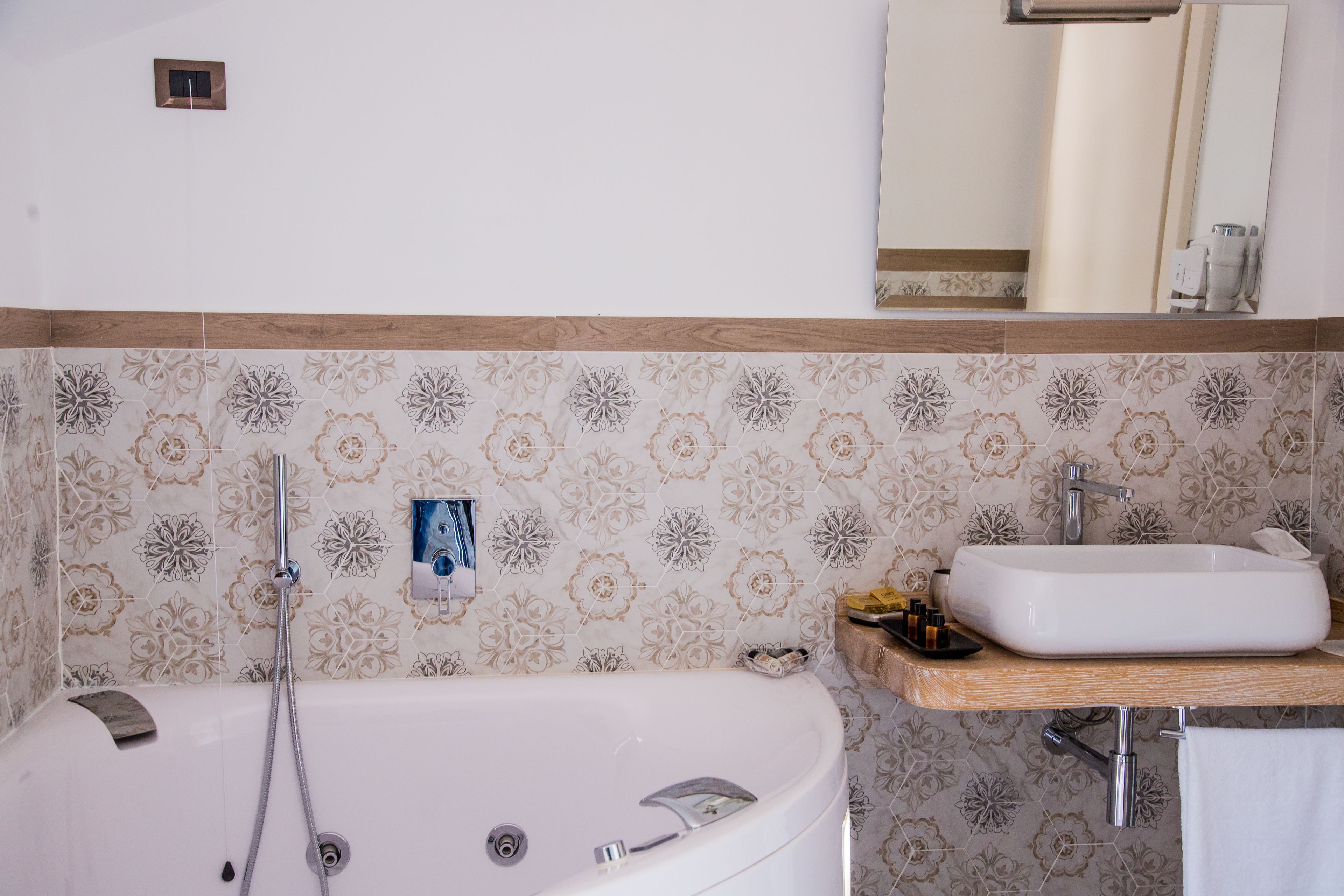 A bathroom with a bathtub, a sink, and a mirror.